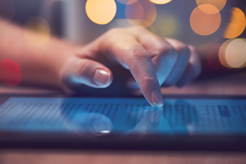 A hand interacting with a tablet