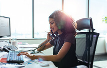 Woman at computer on the phone